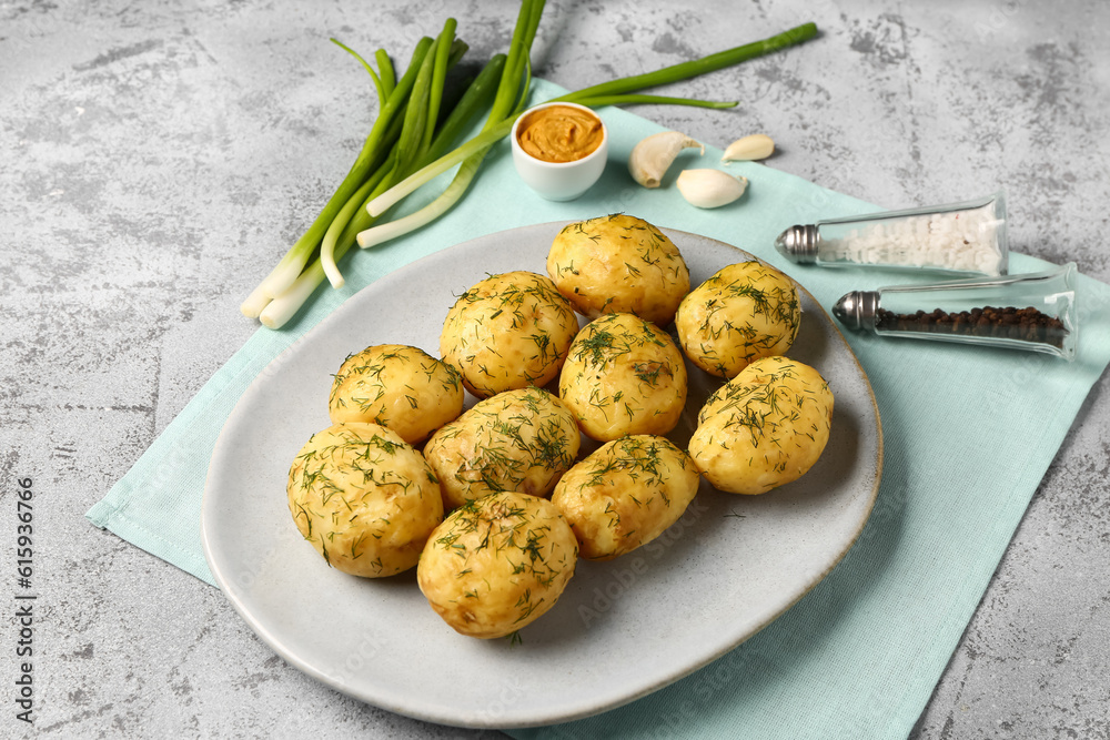 Plate of boiled baby potatoes with dill and mustard on grey background