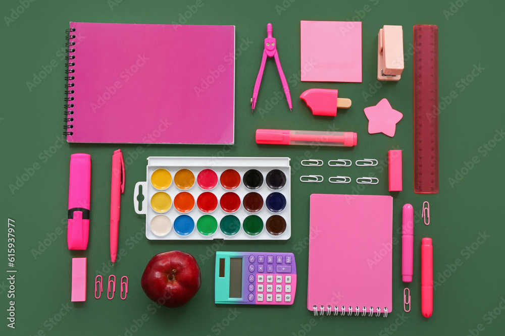 Fresh red apple with calculator and different stationery on green background