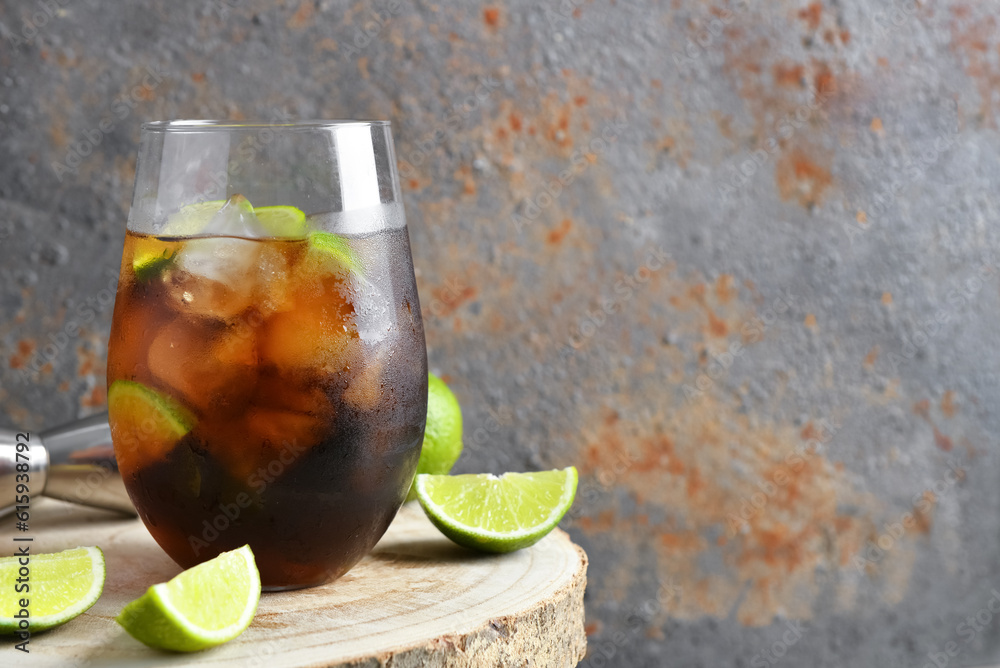 Glass of cold Cuba Libre cocktail on wooden table