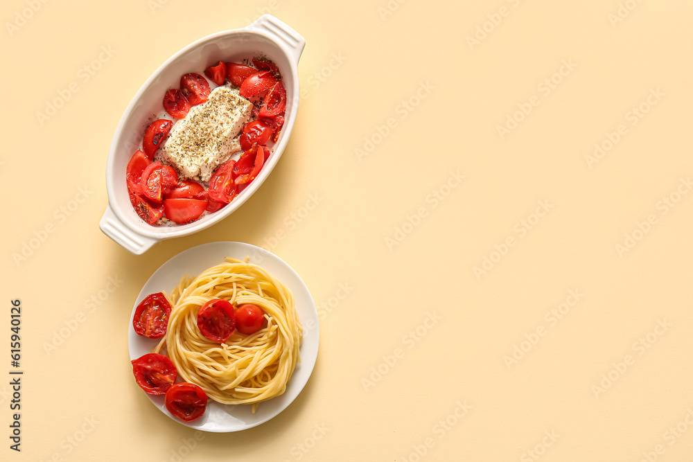 Baking dish with tomatoes, feta cheese and pasta on yellow background