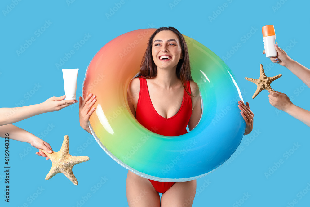 Young woman and female hands with sunscreen cream and starfishes on blue background