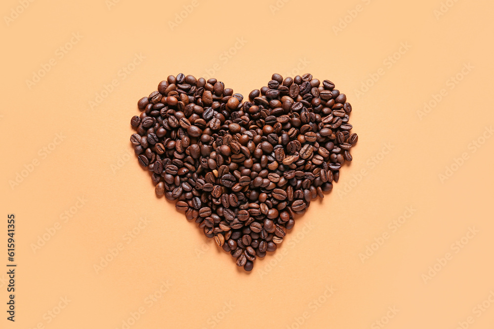 Heart made of coffee beans on orange background