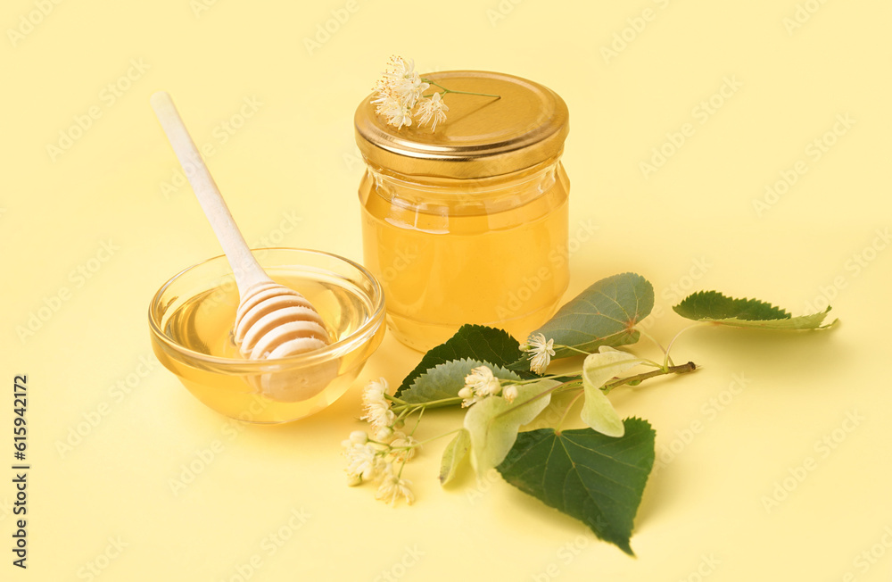 Jar and glass bowl with linden honey on yellow background