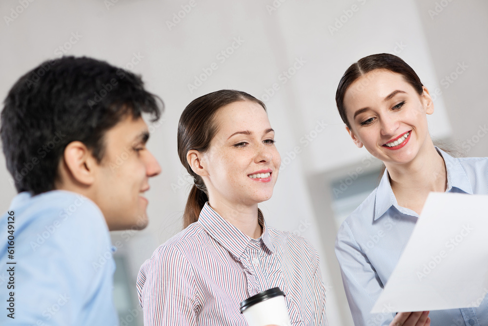 colleagues discuss documents sitting at a small table