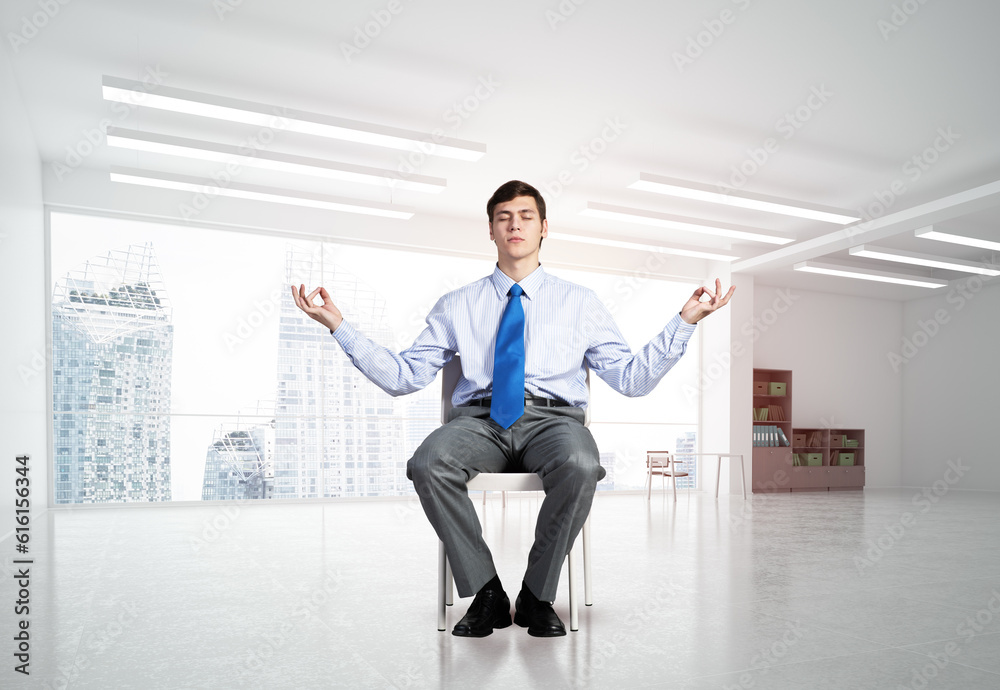 young businessman meditating in the office