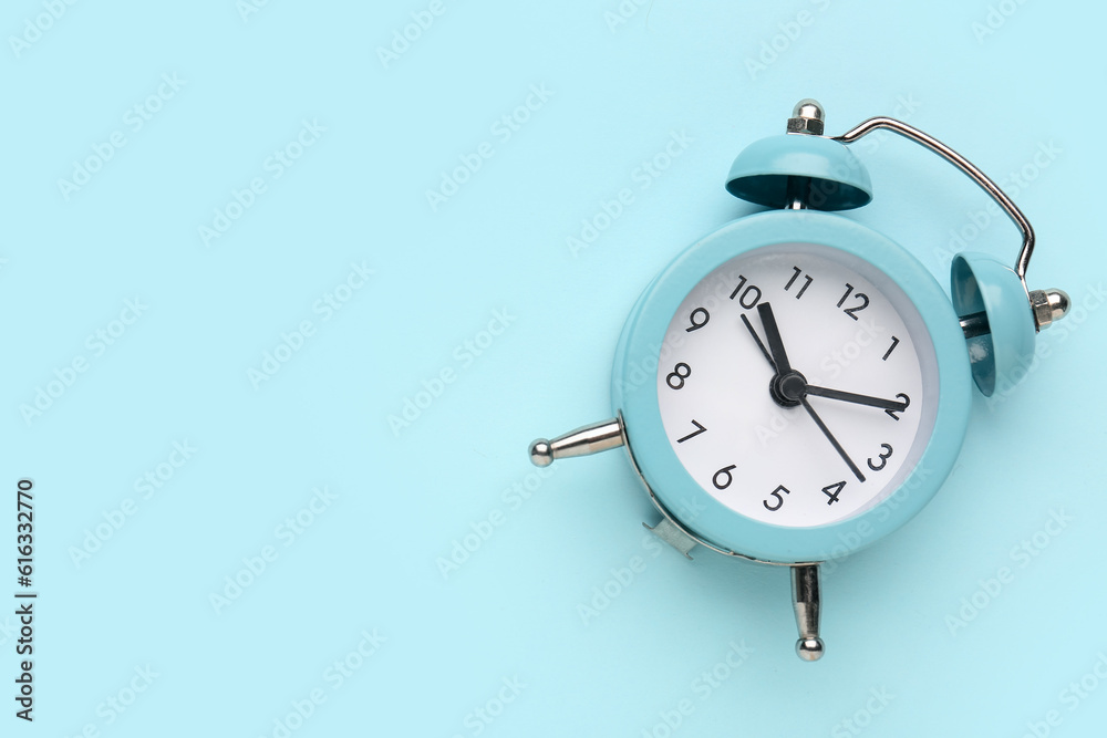 Alarm clock on blue background