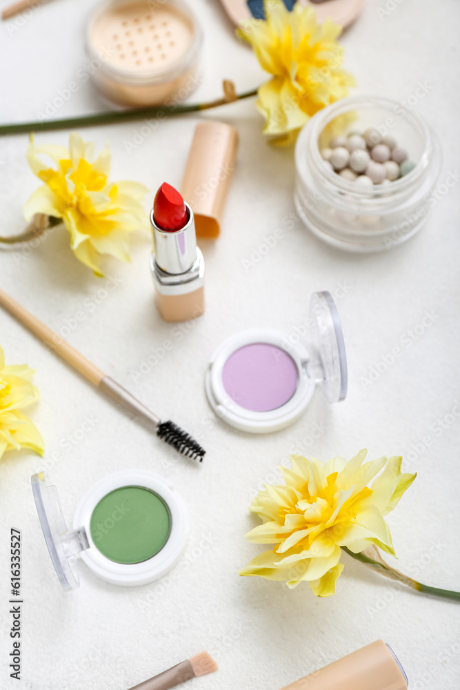 Beautiful daffodils with different cosmetics on white background