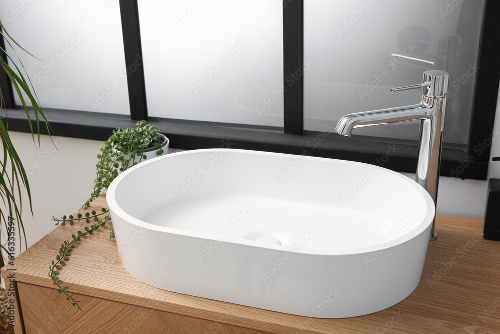 White sink and houseplant on table in bathroom