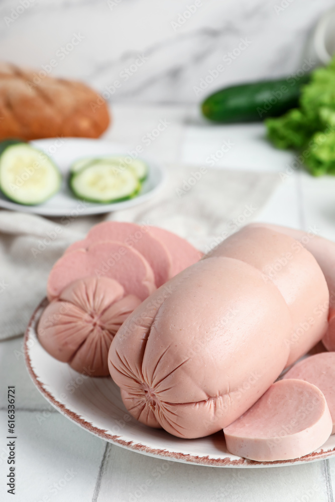 Plate with tasty boiled sausage on table