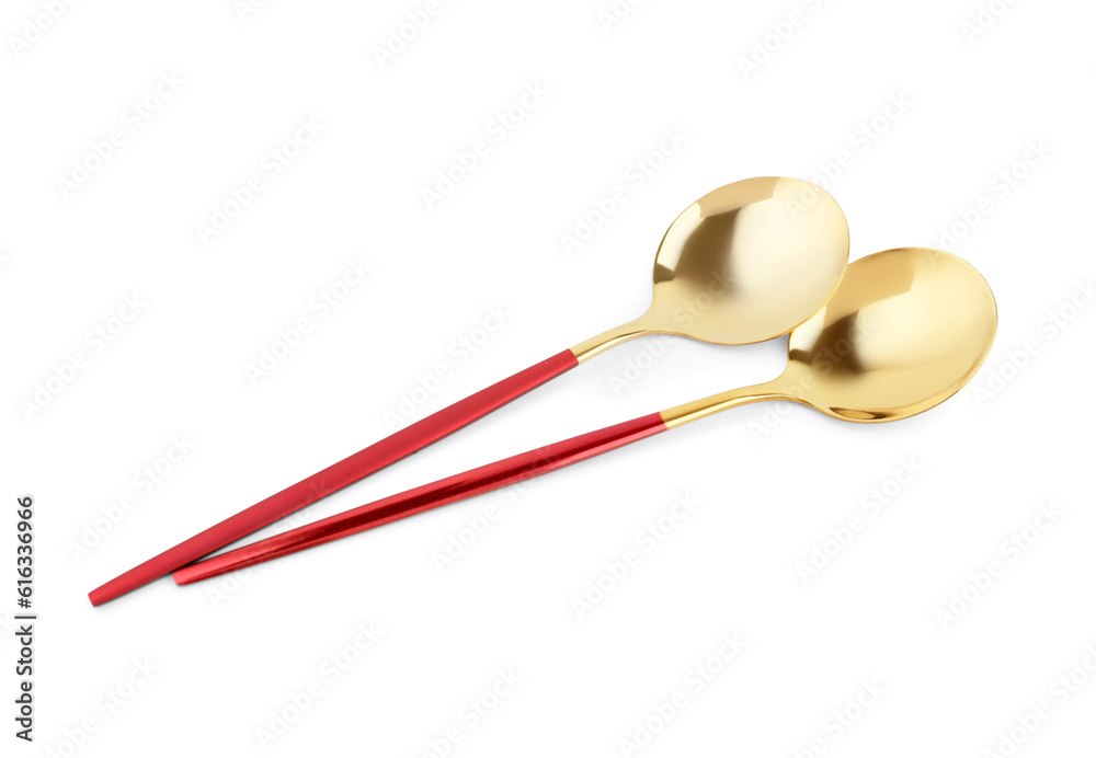 Golden spoons with red handles on white background