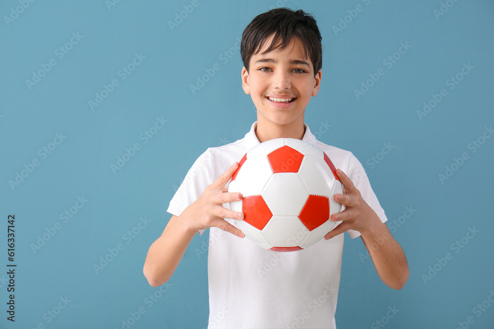 Little boy with soccer ball on blue background