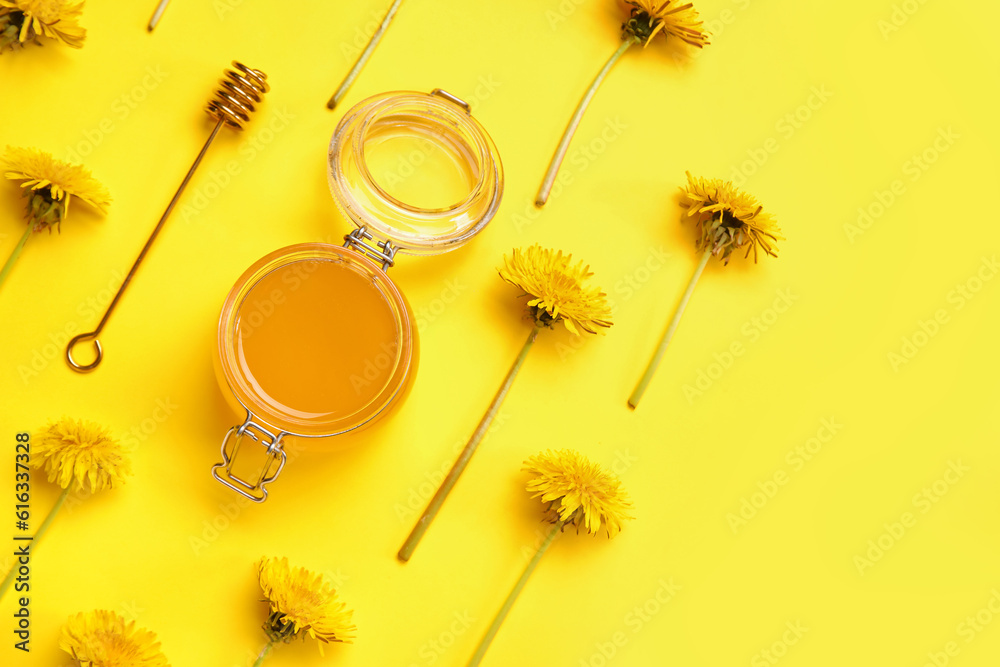 Jar with dandelion honey on yellow background