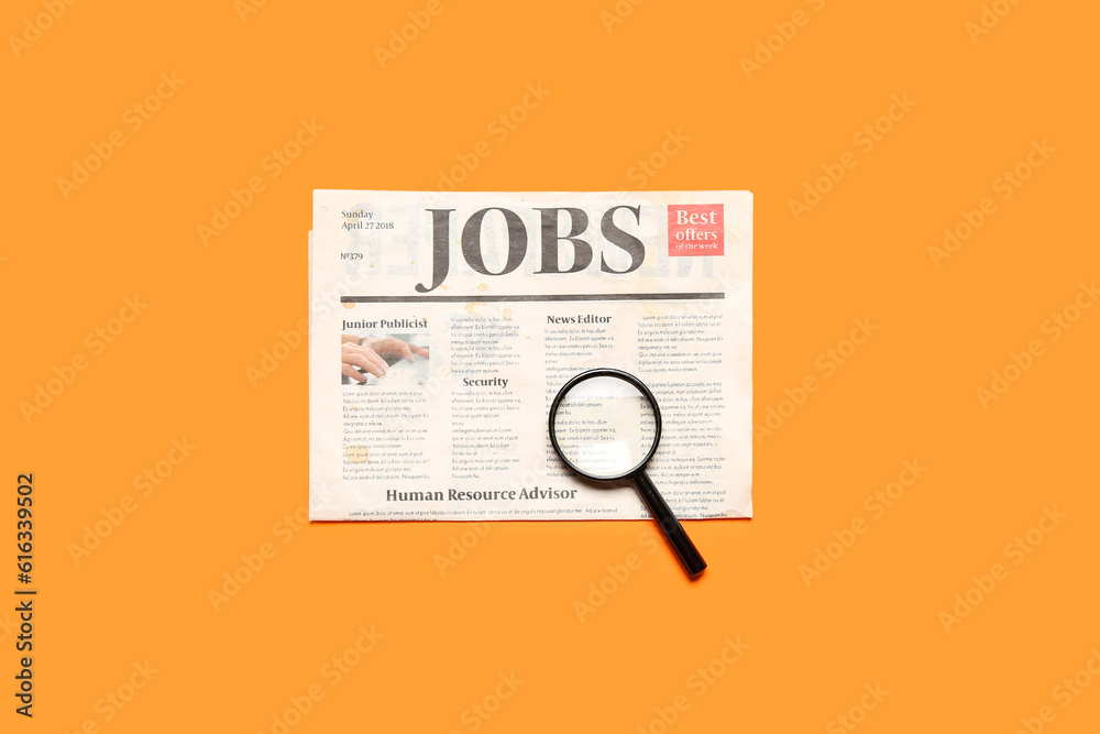 Mini magnifier and newspaper with headline JOBS on orange background. Search concept