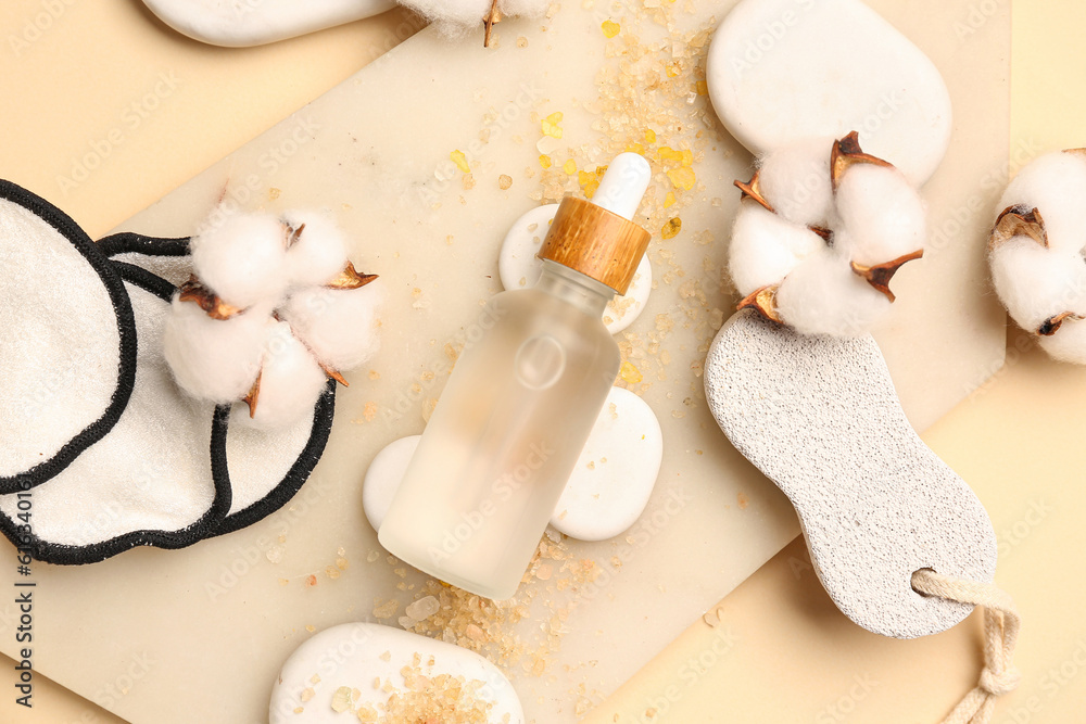 Composition with bottle of essential oil, bath supplies and cotton flowers on color background, clos