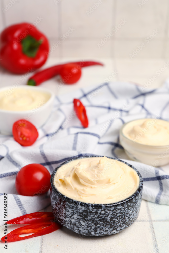 Bowl of tasty cream cheese on white tile background