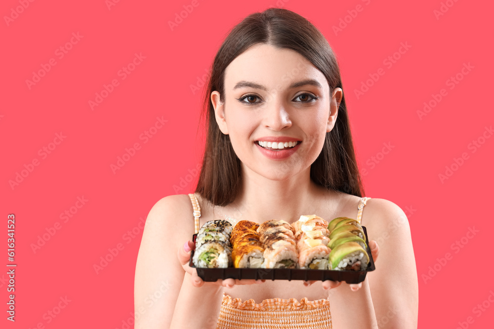 Young woman with sushi on red background, closeup