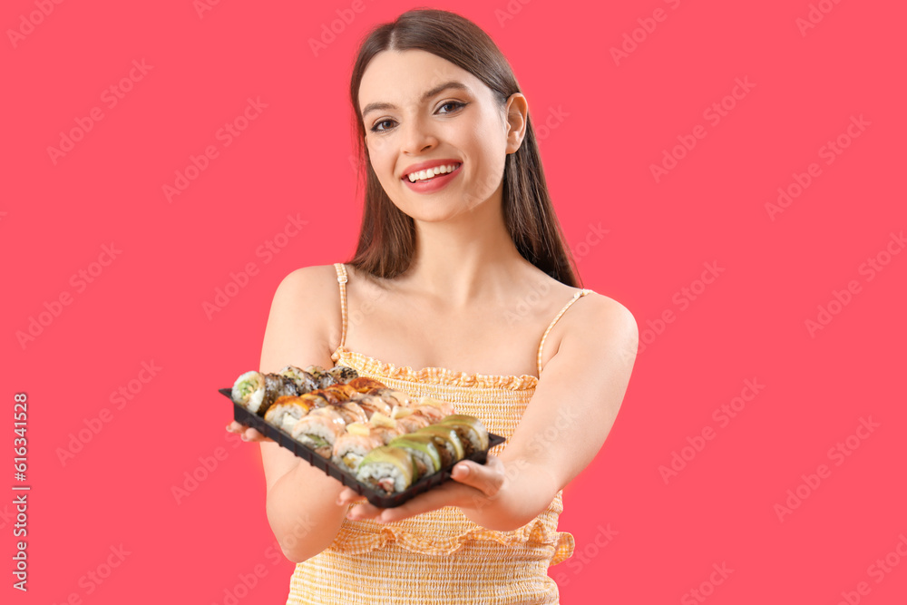 Young woman with sushi on red background