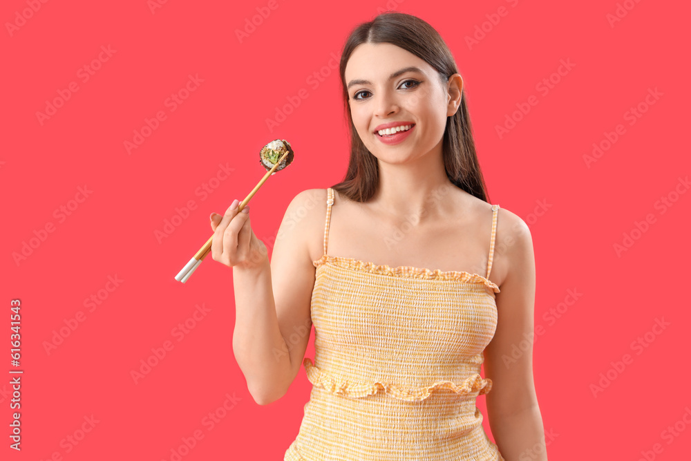 Young woman with sushi roll on red background