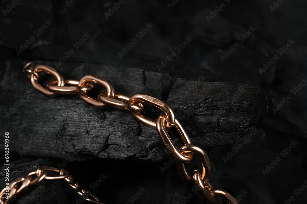 Beautiful chain bracelets on black charcoal, closeup