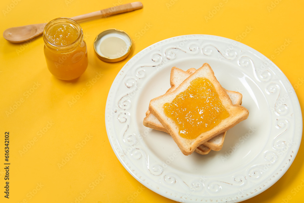 Plate of tasty toasts and jam on color background