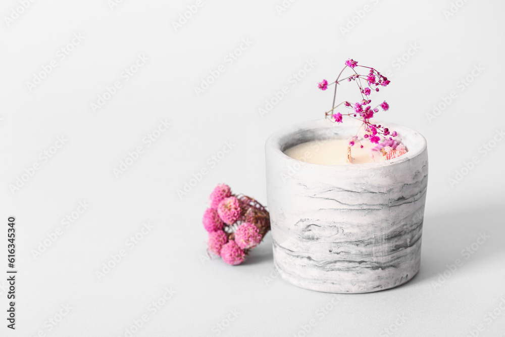 Holder with candle and flowers on white background