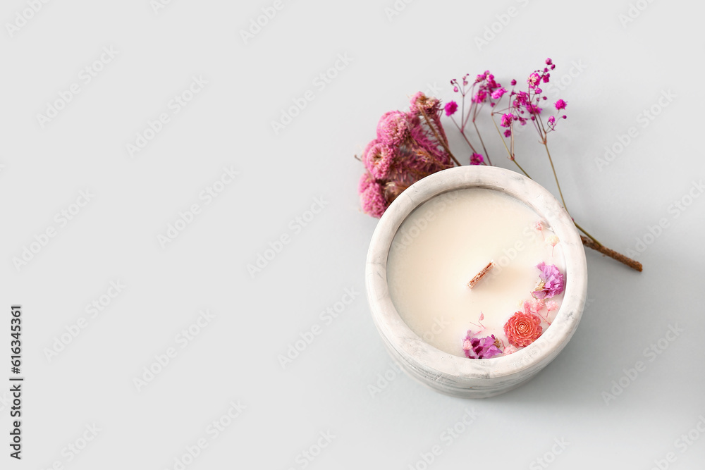 Holder with candle and flowers on white background