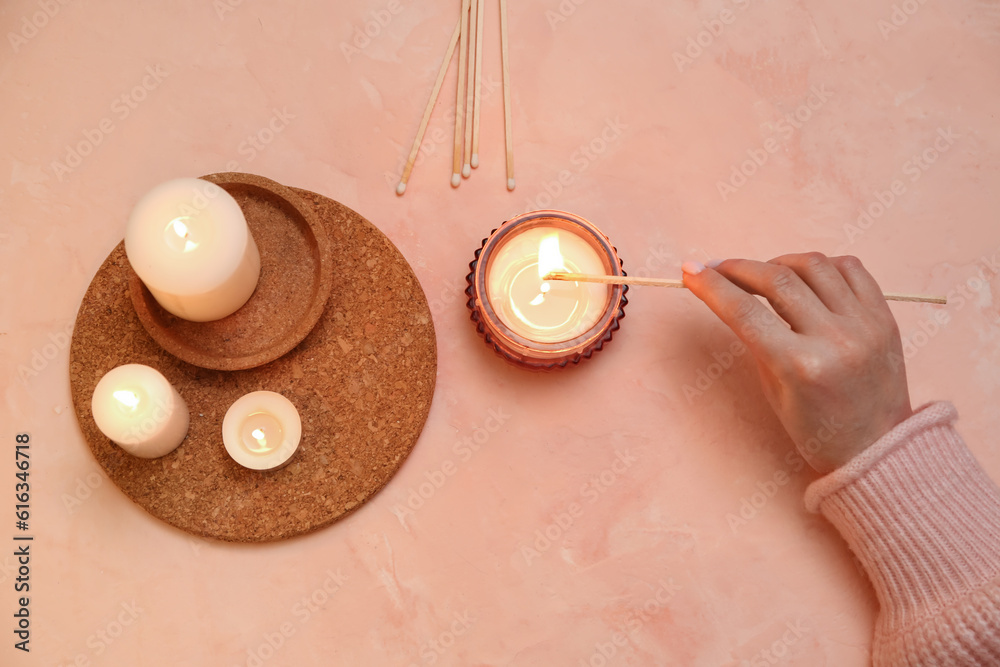 Woman lightning candle on beige background