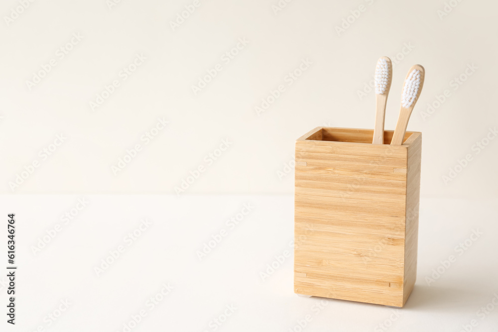 Bamboo tooth brushes in holder on light background