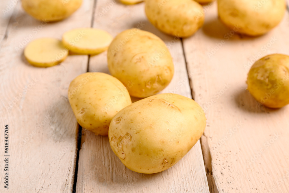 Raw baby potatoes on white wooden background