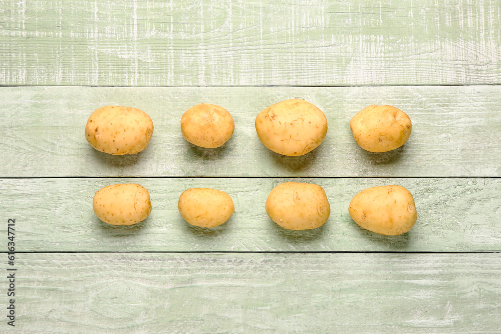 Raw baby potatoes on green wooden background