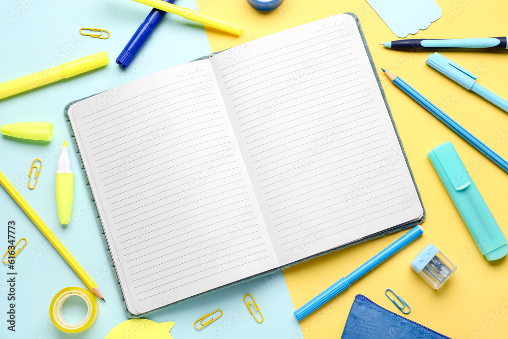 Notebook with different stationery on color background