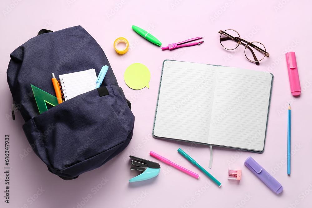 Backpack with notebooks, eyeglasses and different stationery on lilac background