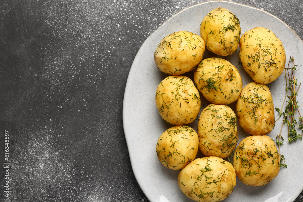 Plate of boiled baby potatoes with dill on grey background