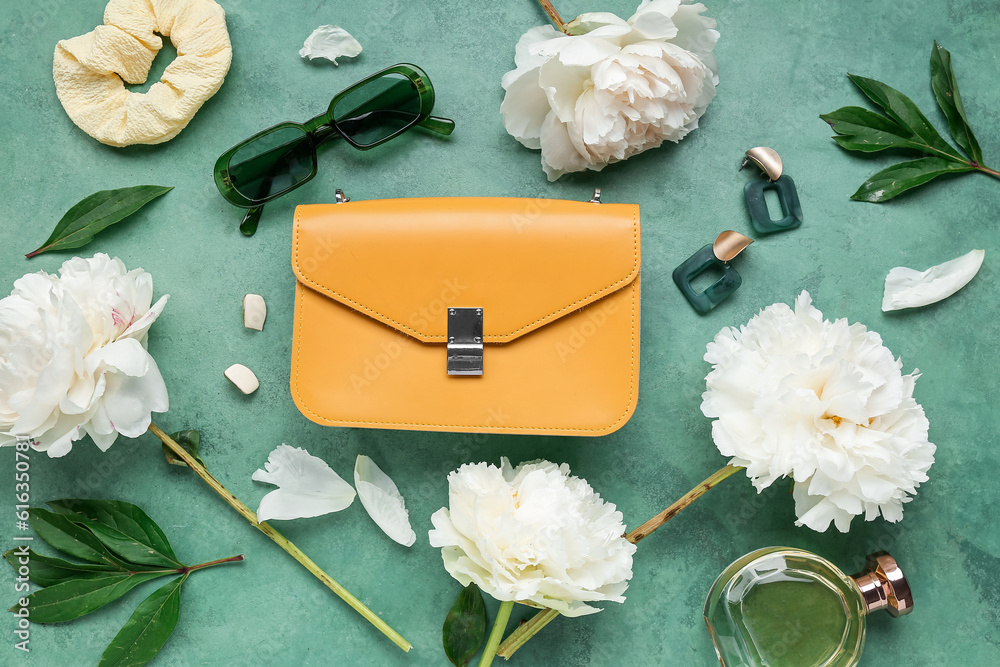 Composition with stylish female accessories, bottle of perfume and beautiful peony flowers on color 