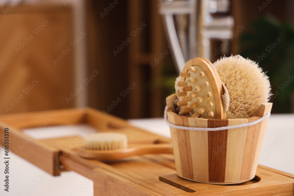 Bucket with massage brushes on stand in bathroom, closeup