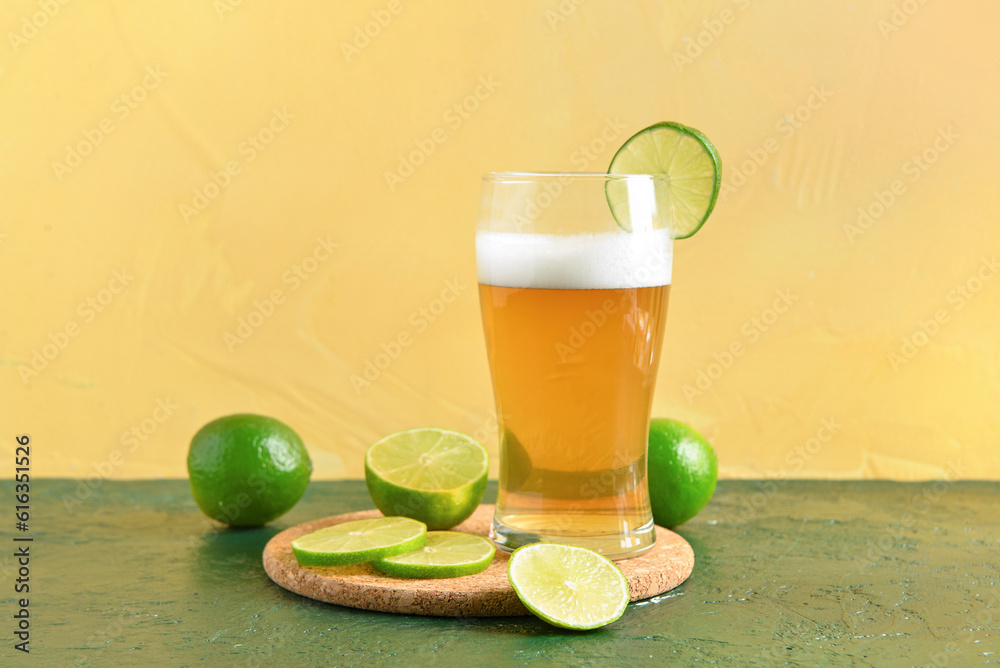 Glass of cold beer with lime on table