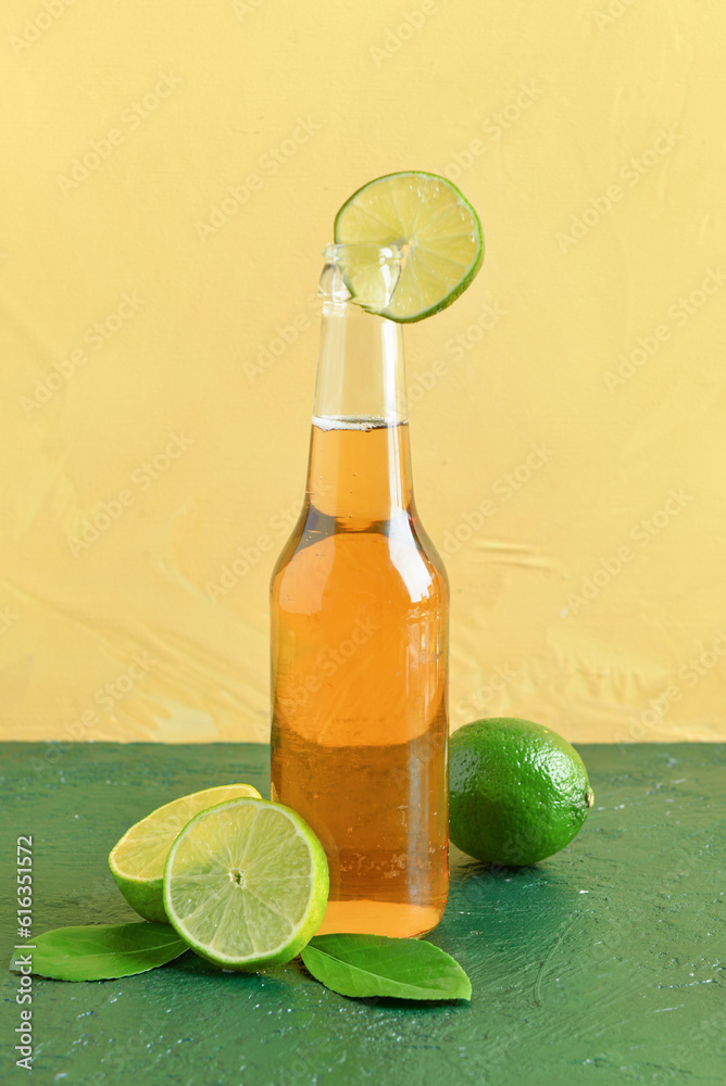 Bottle of cold beer with lime on table