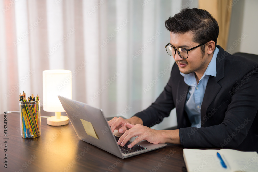 Asian businessman working with laptop on desk at home. Work from home concept.