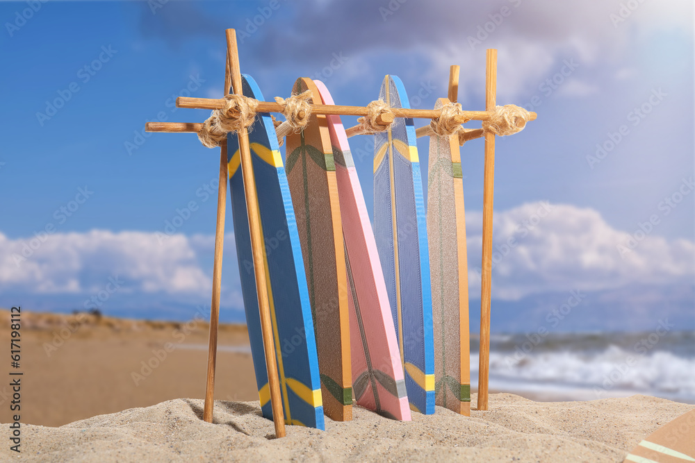 Stand with different surfboards on beach sand