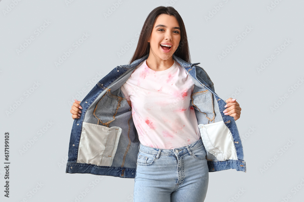 Young woman in tie-dye t-shirt on light background