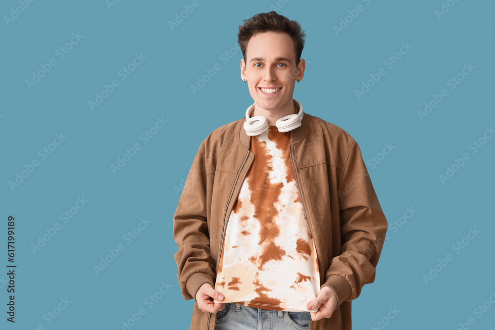 Young man in tie-dye t-shirt on blue background