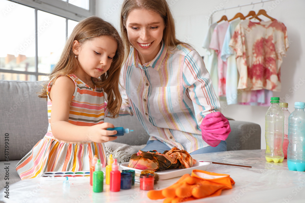 Little girl with her sister making tie-dye t-shirt at home