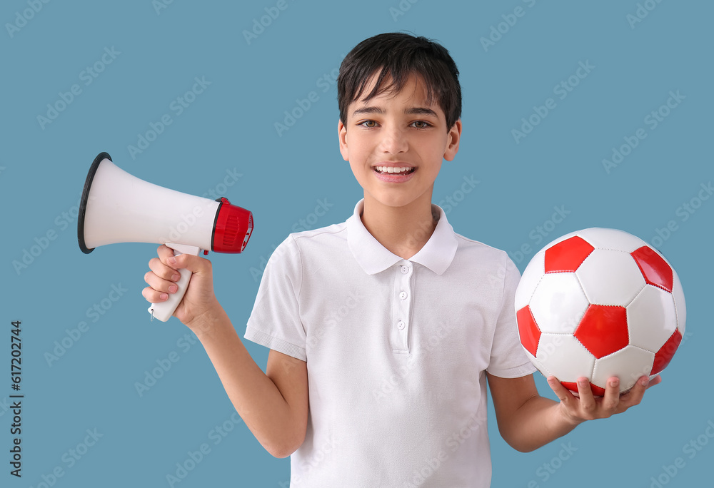 Little boy with soccer ball and megaphone on blue background