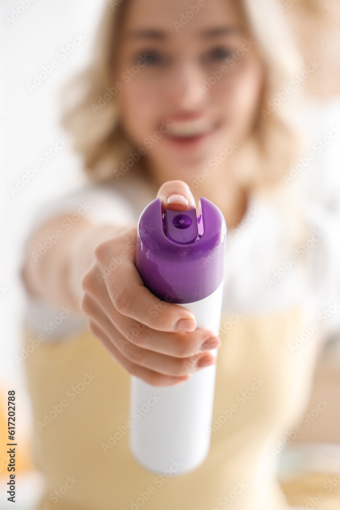 Young woman with air freshener in bedroom, closeup