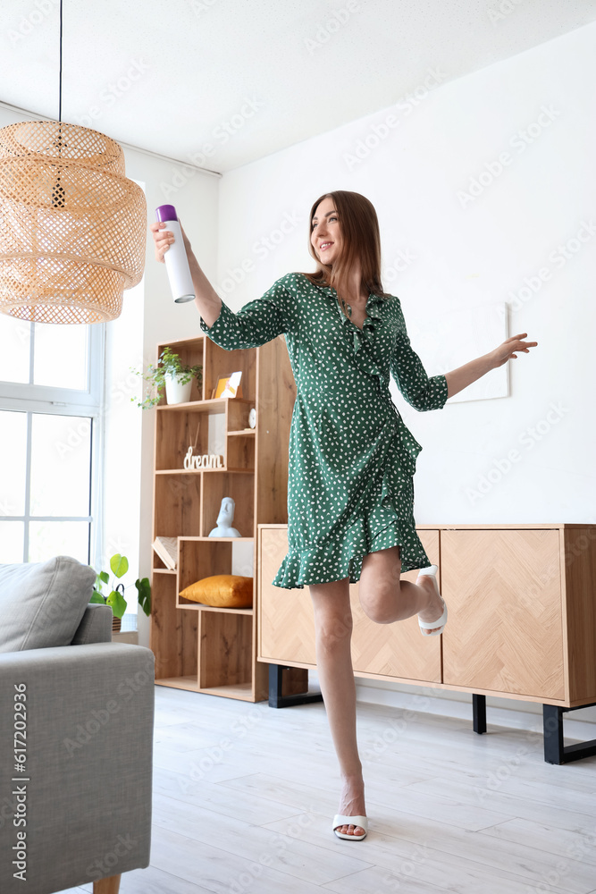 Young woman with air freshener at home