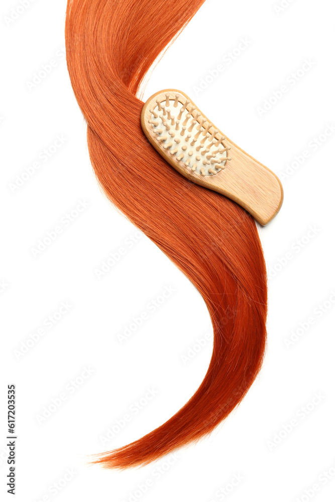 Ginger hair strand and brush on white background, closeup