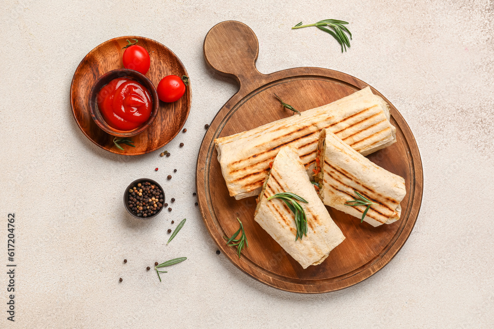 Board of tasty shawarma and plate with ketchup on white background