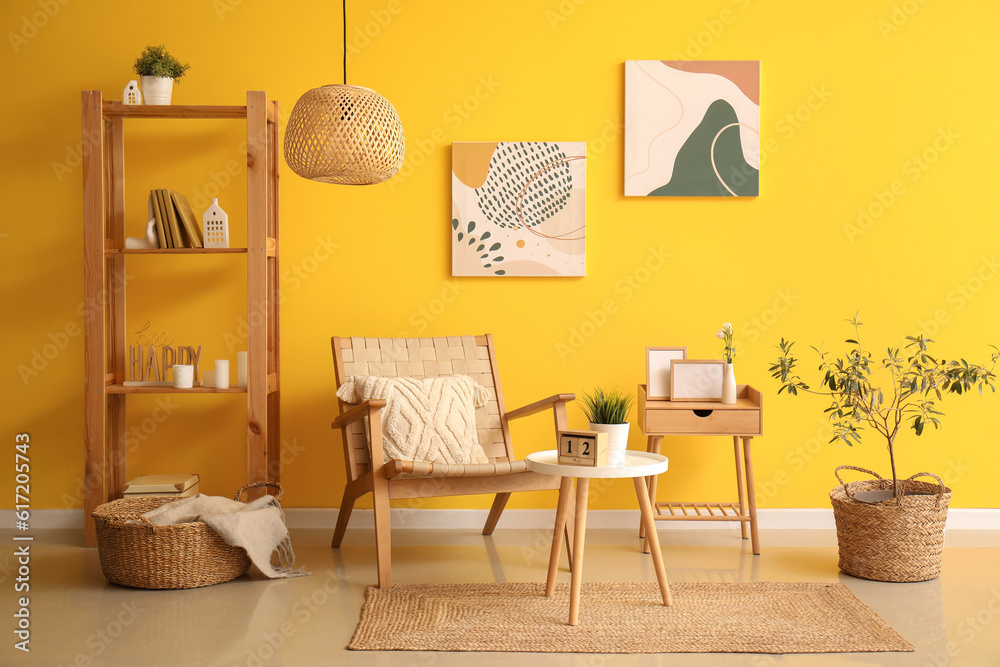 Interior of living room with armchair, tables and shelving unit