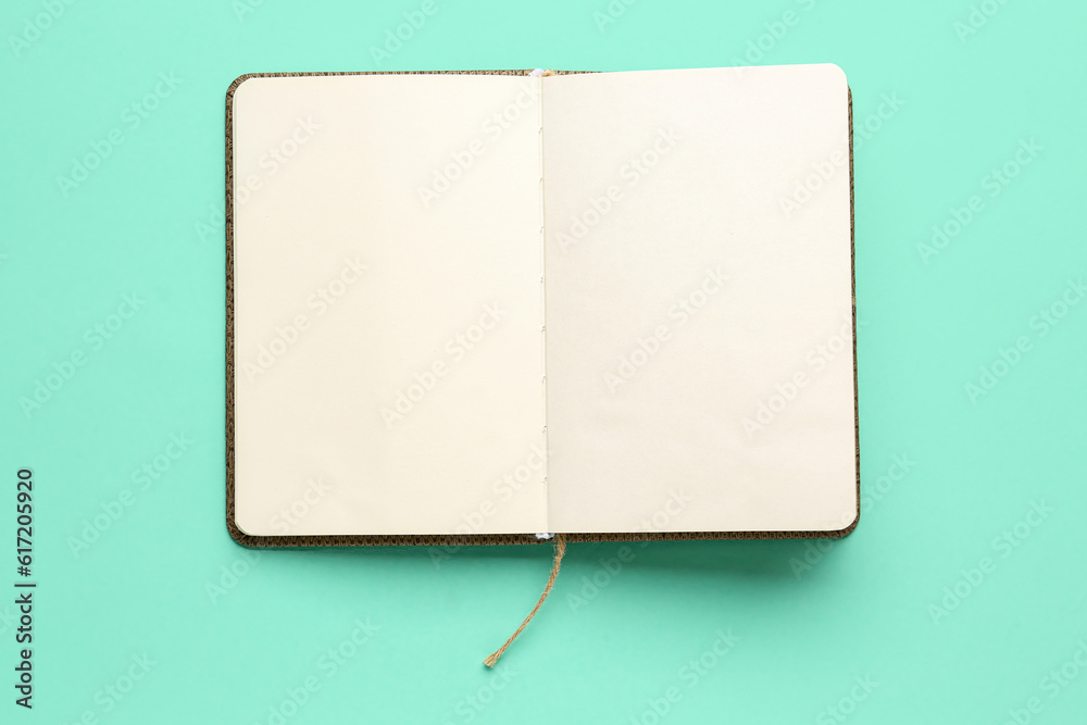 Blank open notebook on color background