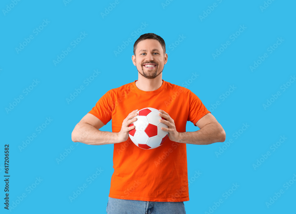 Happy man with soccer ball on blue background